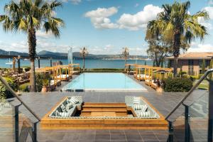 a swimming pool with palm trees and a resort at Kube Saint-Tropez in Saint-Tropez