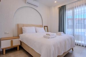 a bedroom with a large bed with towels on it at Kaura Villas in Milas