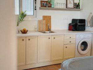 a kitchen with a sink and a washing machine at Sun Garden House Athens in Nea Makri