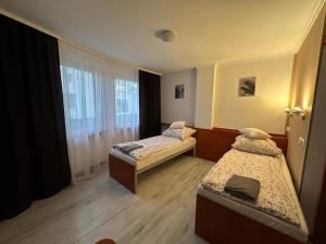 a room with two beds and a window at Bianco - pokoje noclegowe in Częstochowa