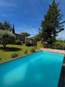 a swimming pool in the yard of a house at Le Petit Moras in Chomérac