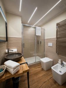 a bathroom with a sink and a toilet and a tub at Favola Guesthouse Affittacamere in Nettuno