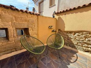 two green chairs sitting next to a building at YourHouse O Rexo in Allariz