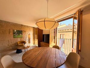 a dining room with a wooden table and a room with a balcony at YourHouse O Rexo in Allariz