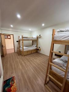 a room with three bunk beds in a room at Snow Den hostel in Leh