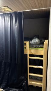 a bedroom with a bunk bed with black curtains at ゲストハウスヤドカリ in Nanao