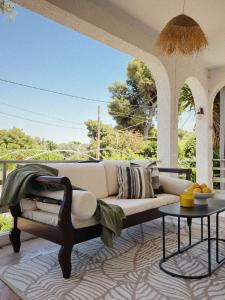 a living room with a couch and a table at Sun Garden House Athens in Nea Makri