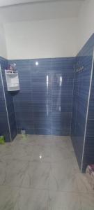 a bathroom with blue tiled walls and a shower at fenêtre de la mère in Al Hoceïma +17 photos