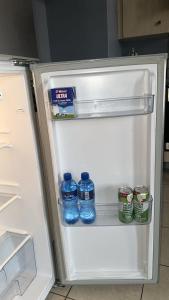 an open refrigerator with bottles of water in it at Swanky Spectacular Hotel in Johannesburg