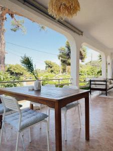 a wooden table and chairs on a patio at Sun Garden House Athens in Nea Makri