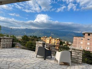 a balcony with two chairs and a view of a city at Apartament Drasa in Gjirokastër