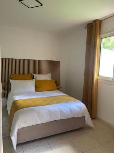 a bedroom with a large bed with a window at La Villa Nature in La Plaine des Cafres