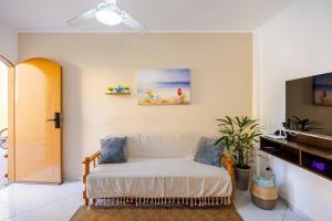 a living room with a couch and a piano at Casa a 500m da Praia do Sape in Ubatuba