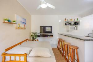 a dining room with a table and chairs and a kitchen at Casa a 500m da Praia do Sape in Ubatuba