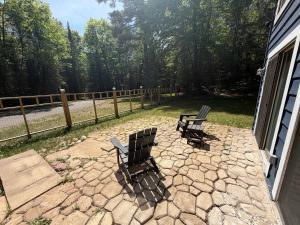 two chairs sitting on a patio next to a fence at Big St Germain Hideaway in Sayner