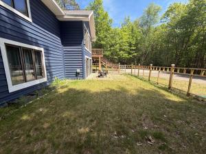 a yard next to a house with a fence at Big St Germain Hideaway in Sayner