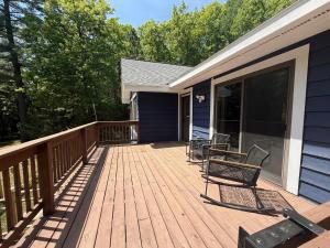 a wooden deck with chairs on a house at Big St Germain Hideaway in Sayner