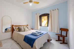 a bedroom with a bed with towels on it at Casa a 500m da Praia do Sape in Ubatuba