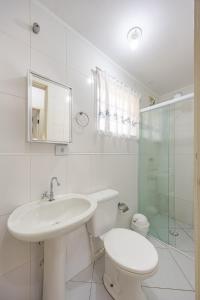 a bathroom with a sink and a toilet and a shower at Casa a 500m da Praia do Sape in Ubatuba +34 photos