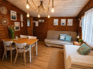 a living room with a table and a couch at Domki Promyk in Mrzeżyno