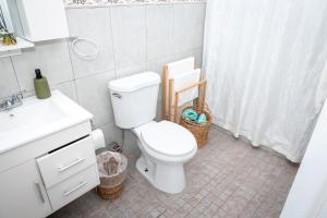 a white bathroom with a toilet and a sink at Cozy West Coast Studio in Cabo Rojo +15 photos