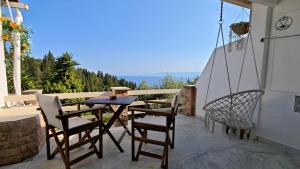 a patio with a swing and a table and chairs at Liokorni Village in Gaios