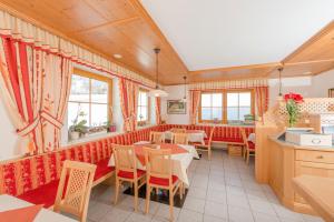 un restaurante con mesas, sillas y ventanas en Pernerhof, en Ramsau am Dachstein