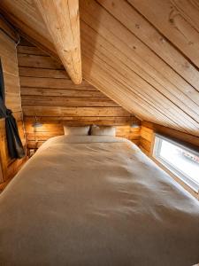 a large bed in a wooden room with a window at Cabin in the Woods in Malung