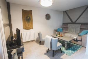 a living room with a table and a couch at Le Cottage Bleu- In the Heart of Riquewihr by La Maison Bleue in Riquewihr