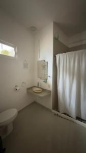 a white bathroom with a toilet and a sink at Hotel Casa Xicun in Tepoztlán +32 photos
