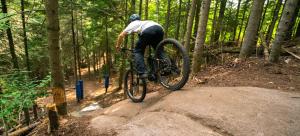 a man doing a trick on a bike in the woods at Condo familial Mont Blanc, accès ski in Ski out in Saint-Faustin