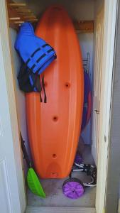 an orange kayak and other items in a closet at Condo familial Mont Blanc, accès ski in Ski out in Saint-Faustin