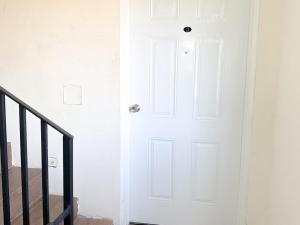 a white door in a room with a staircase at The Vista Inn Studio #3 in Falmouth