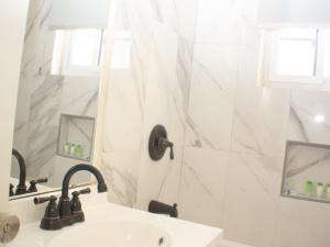 a white bathroom with a sink and a shower at The Vista Inn Studio #3 in Falmouth +3 photos