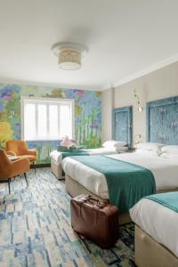a hotel room with three beds and a window at Ashdown Park Hotel in Gorey
