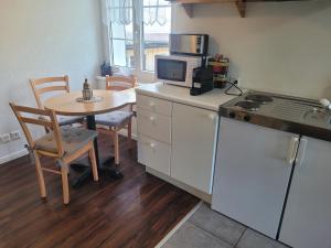 a small kitchen with a table and a microwave at Rest. Beaver Creek Ranch in Rothenthurm