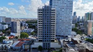 a tall building in the middle of a city at Flat no Condomínio Metrópolis - Ilha do Leite in Recife