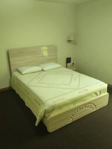 a bedroom with a large bed with a wooden headboard at Vincent Suites Hotel in Pasto