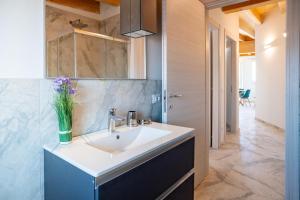 a bathroom with a sink and a vase of flowers at Venti del Garda in Montinelle +122 photos