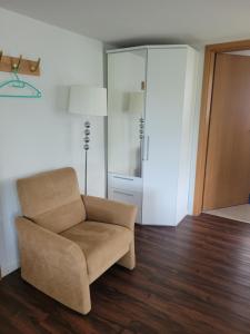 a living room with a chair and a closet at Rest. Beaver Creek Ranch in Rothenthurm