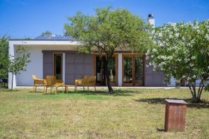 a house with chairs and a table in a yard at Casa Vacanza 2 Mari in Alghero