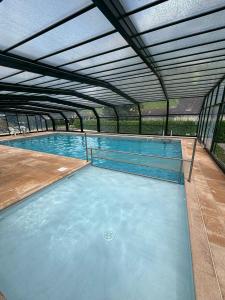 a large swimming pool with an open roof at Appartement Le Refuge du Vautour in Bielle