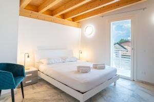 a white bedroom with a bed and a window at Venti del Garda in Montinelle