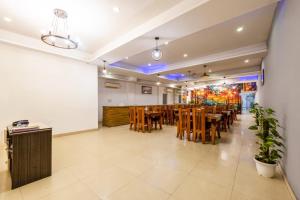 ein Restaurant mit Tischen, Stühlen und einer Tafel in der Unterkunft Hotel Seven Inn Pride Near IGI Delhi Airport in Neu-Delhi
