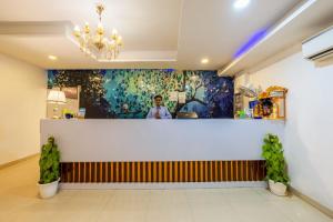 eine Bar in einem Restaurant mit einem Gemälde an der Wand in der Unterkunft Hotel Seven Inn Pride Near IGI Delhi Airport in Neu-Delhi