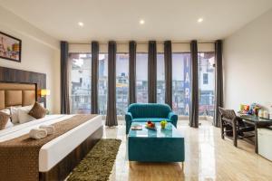 ein Schlafzimmer mit Bett, Stuhl und Schreibtisch in der Unterkunft Hotel Seven Inn Pride Near IGI Delhi Airport in Neu-Delhi