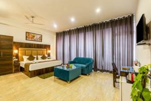 ein Hotelzimmer mit einem Bett und einem blauen Stuhl in der Unterkunft Hotel Seven Inn Pride Near IGI Delhi Airport in Neu-Delhi