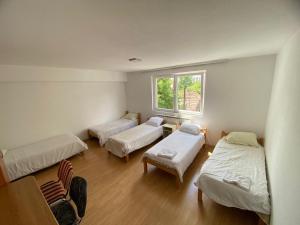 a room with three beds and a window at Otoka Hostel in Sarajevo +50 photos
