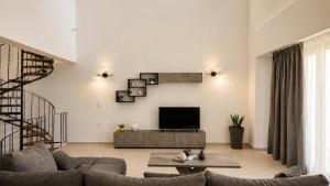 a living room with a couch and a tv at Balis Villa Naxos in Agios Prokopios