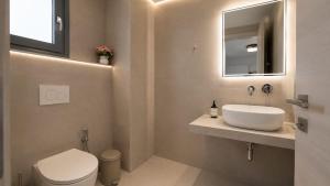 a bathroom with a sink and a toilet and a mirror at Balis Villa Naxos in Agios Prokopios +7 photos